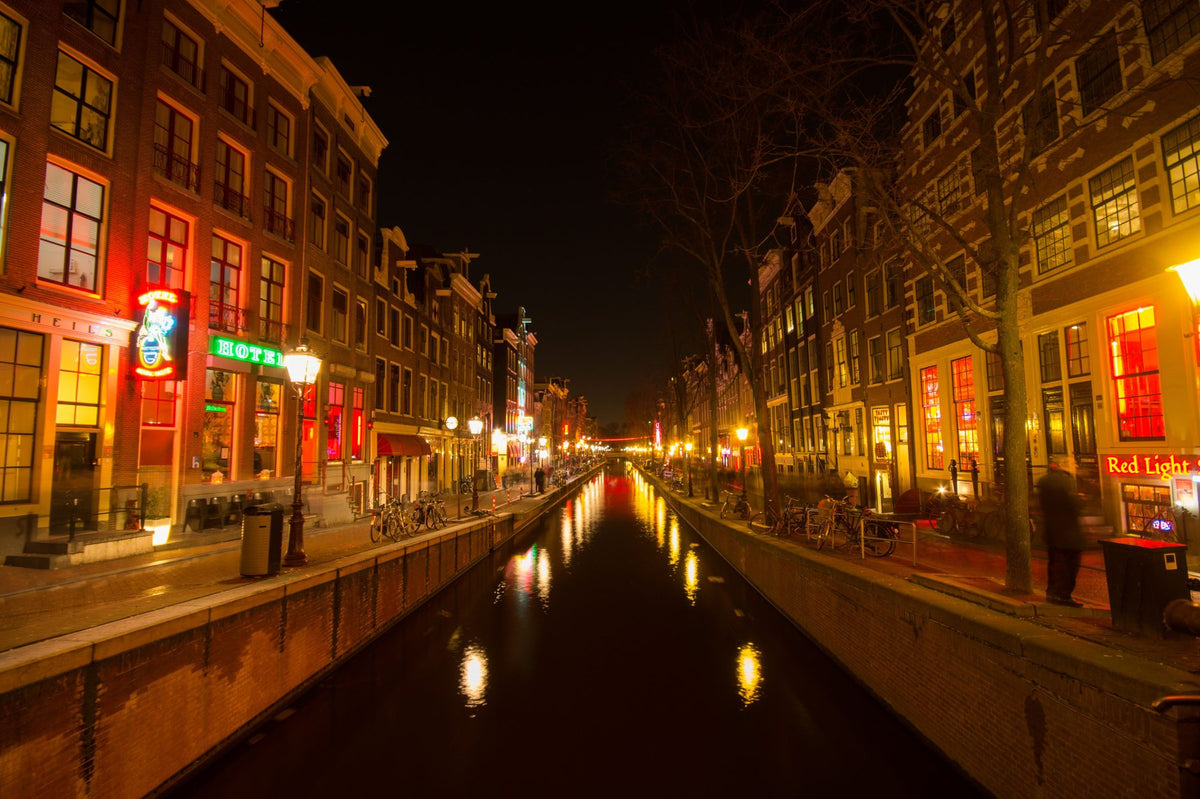 Amsterdam canal at night with red-lit windows